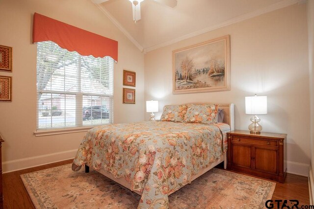 bedroom with ceiling fan, ornamental molding, dark wood-type flooring, and vaulted ceiling