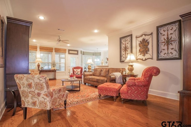 living room with hardwood / wood-style floors, ceiling fan, and crown molding