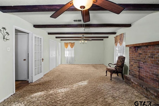 sitting room featuring beamed ceiling, carpet floors, and ceiling fan