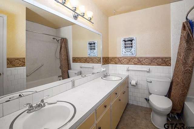 full bathroom featuring shower / tub combo, tile walls, vanity, tile patterned floors, and toilet