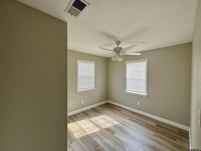 empty room with ceiling fan and light wood-type flooring