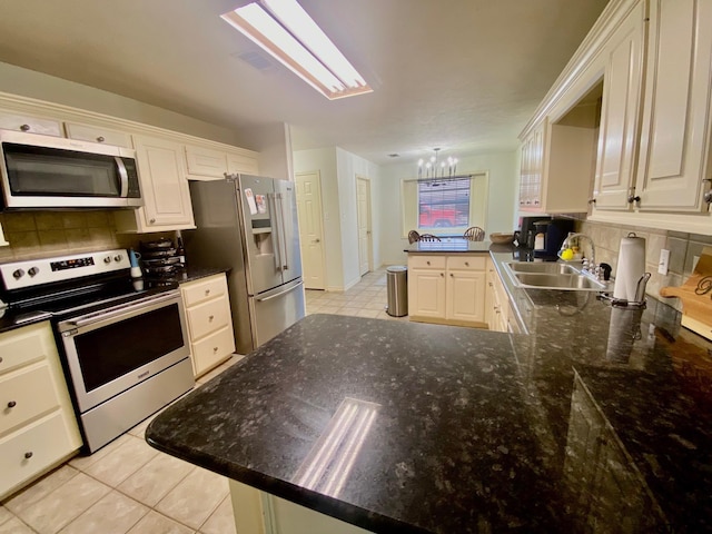 403 Aspen Bend St, Crockett, TX 75835 - kitchen featuring stainless steel appliances, a peninsula, a chandelier, and decorative backsplash