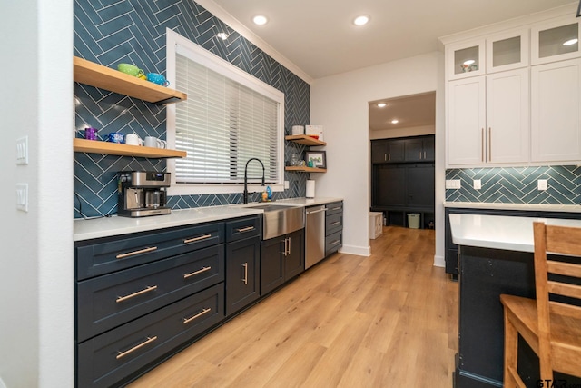 kitchen with sink, tasteful backsplash, stainless steel dishwasher, light hardwood / wood-style floors, and white cabinets