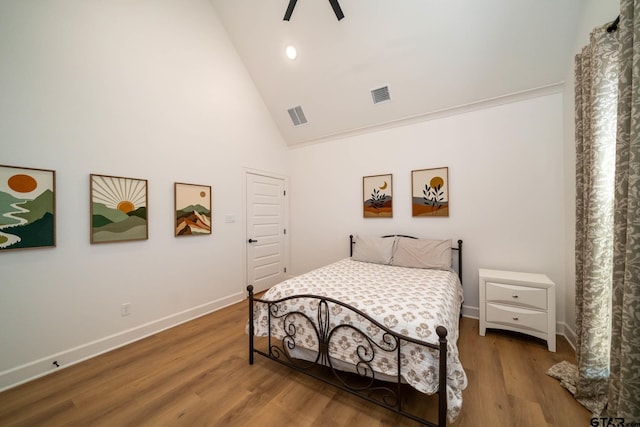 bedroom with hardwood / wood-style flooring, crown molding, and high vaulted ceiling