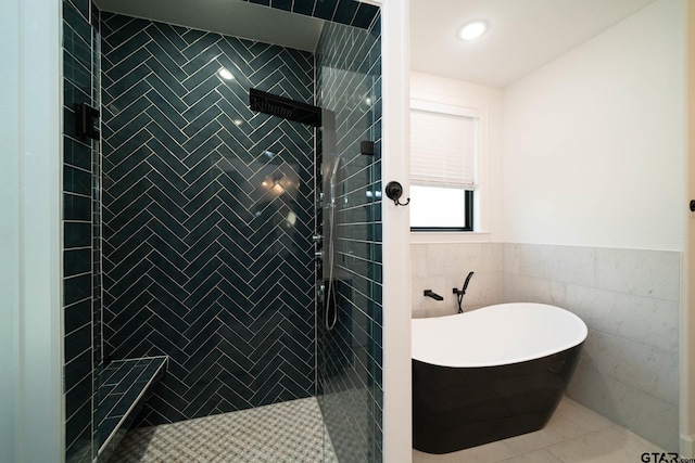 bathroom with tile patterned flooring, independent shower and bath, and tile walls