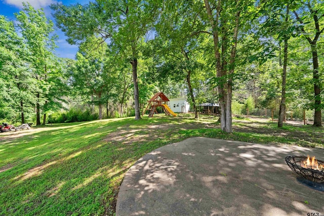 view of yard featuring a fire pit, a patio area, and a playground