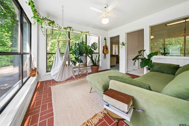 sunroom featuring ceiling fan with notable chandelier