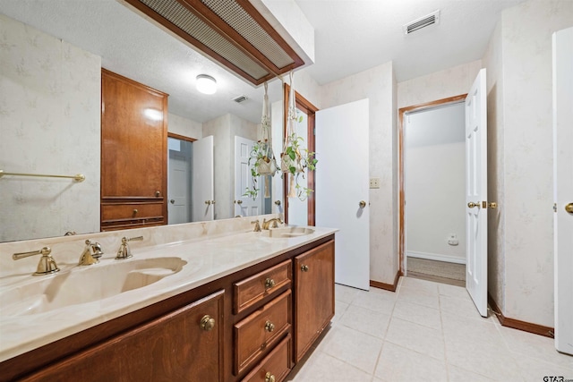 bathroom featuring tile patterned flooring, a textured ceiling, and vanity