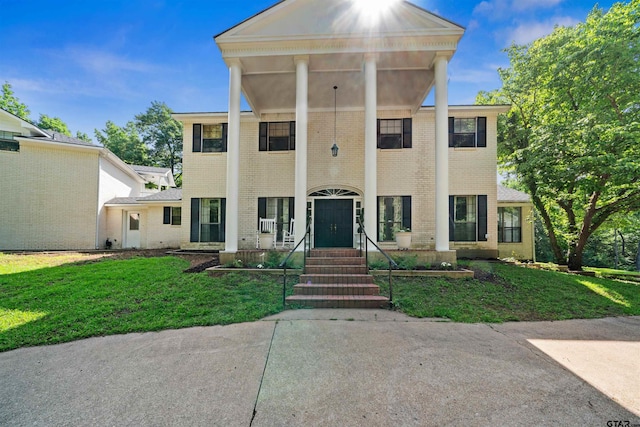 greek revival house featuring a front lawn