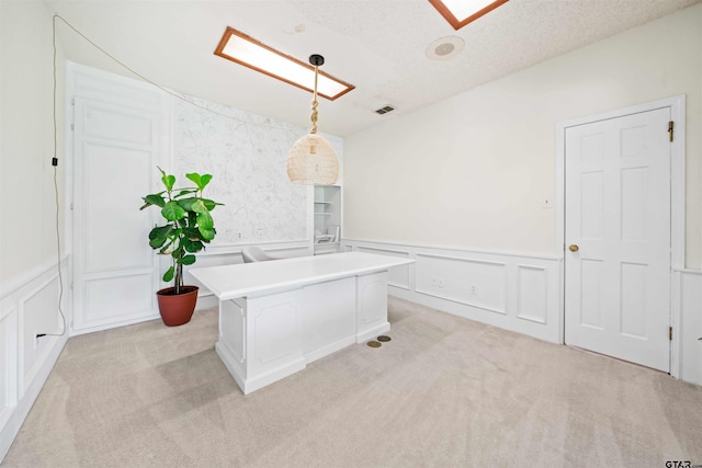 unfurnished office featuring a textured ceiling and light carpet