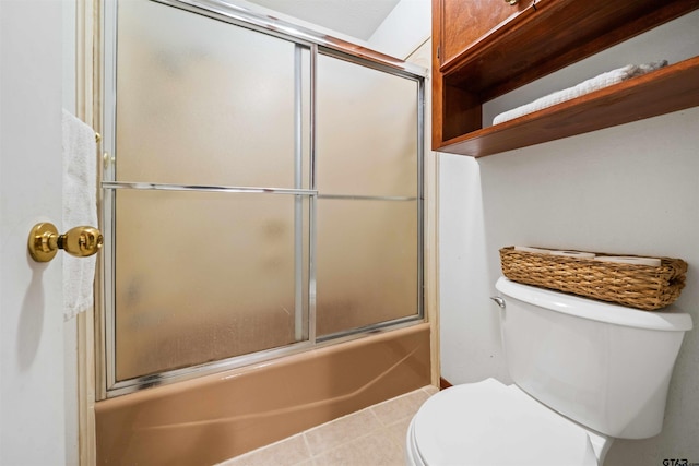 bathroom with toilet and shower / bath combination with glass door