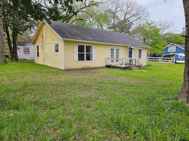 back of property with a yard and french doors