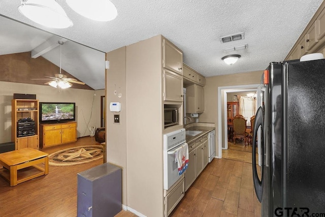 kitchen with wood finished floors, white appliances, a sink, visible vents, and a ceiling fan