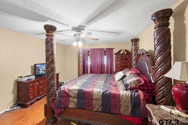 bedroom with a textured ceiling, wood finished floors, and a ceiling fan