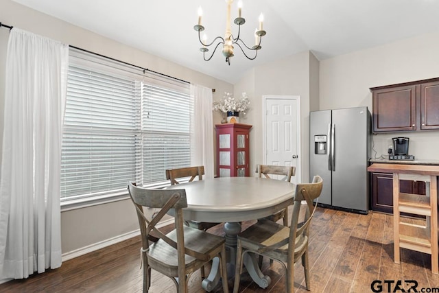 dining space with dark wood-type flooring, lofted ceiling, and a notable chandelier