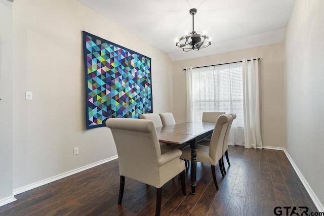 dining space with dark wood-type flooring and a notable chandelier