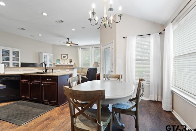 dining space featuring dark hardwood / wood-style flooring, lofted ceiling, sink, and ceiling fan with notable chandelier