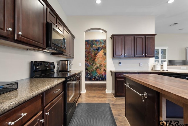 kitchen featuring hardwood / wood-style floors, black electric range oven, butcher block countertops, and dark brown cabinetry