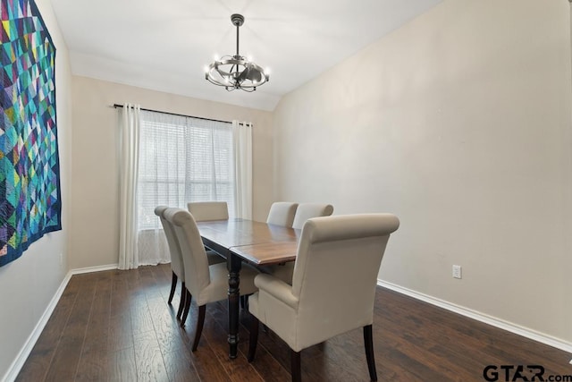 dining area featuring dark hardwood / wood-style flooring, lofted ceiling, and an inviting chandelier