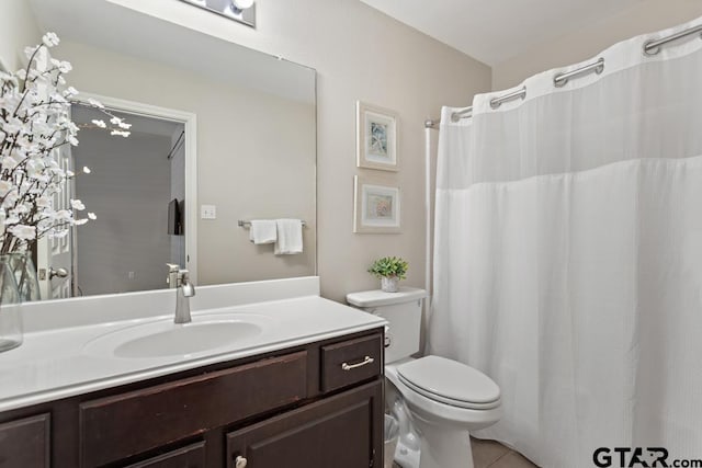 bathroom featuring vanity, tile patterned flooring, and toilet