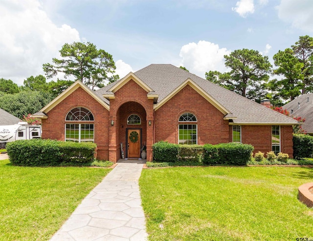 8416 Crooked Trl, Tyler, TX 75703 - traditional-style home featuring brick siding, roof with shingles, and a front lawn