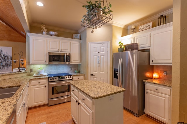 8416 Crooked Trl, Tyler, TX 75703 - kitchen featuring appliances with stainless steel finishes, white cabinets, tasteful backsplash, light wood-style floors, and crown molding