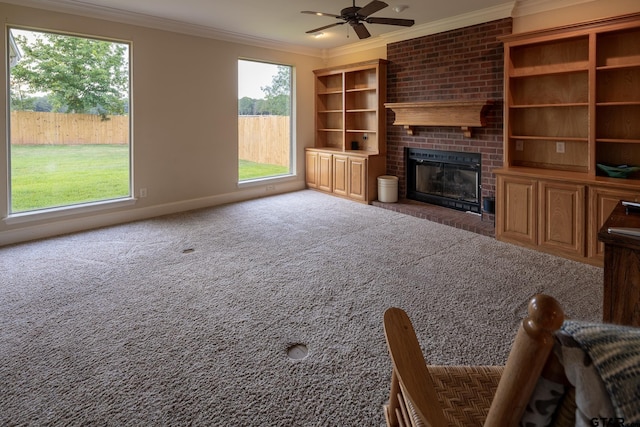 unfurnished living room featuring a brick fireplace, ornamental molding, ceiling fan, and dark colored carpet