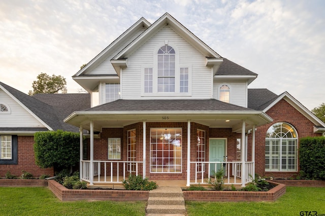 view of front facade featuring a front yard and covered porch