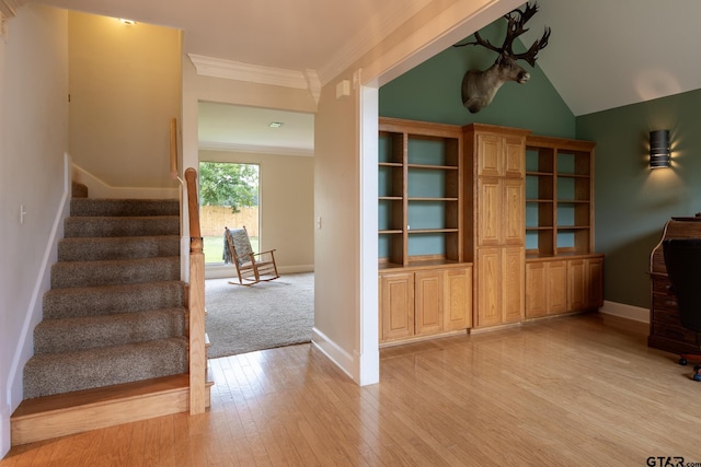 interior space with vaulted ceiling, crown molding, and light hardwood / wood-style flooring