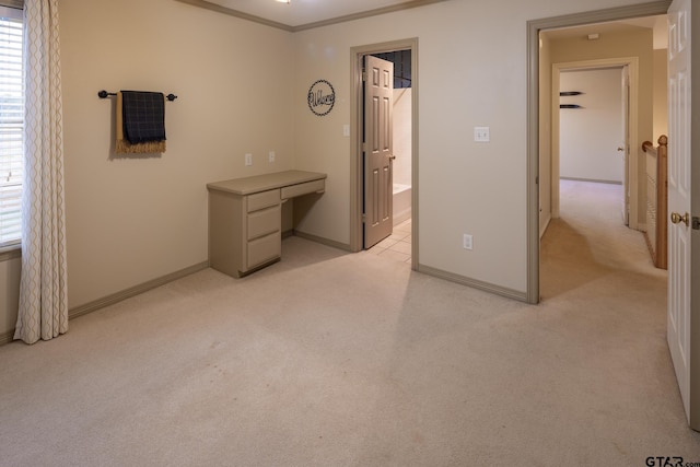 unfurnished bedroom with ensuite bath, ornamental molding, and light colored carpet