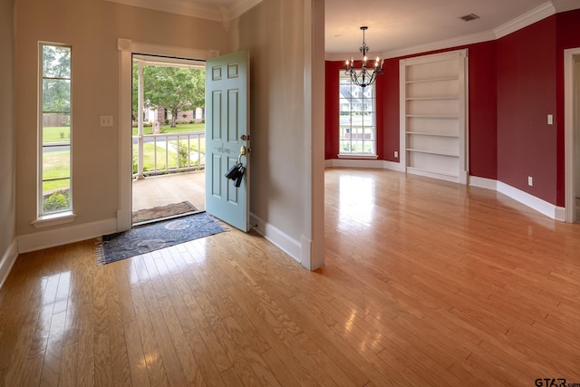 foyer with a notable chandelier, a healthy amount of sunlight, and light wood-type flooring