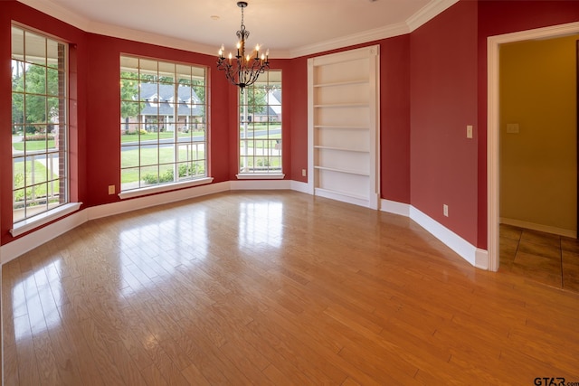 interior space with hardwood / wood-style floors, a chandelier, crown molding, and built in features