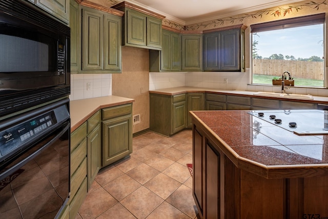 kitchen featuring black appliances, crown molding, green cabinets, sink, and tasteful backsplash