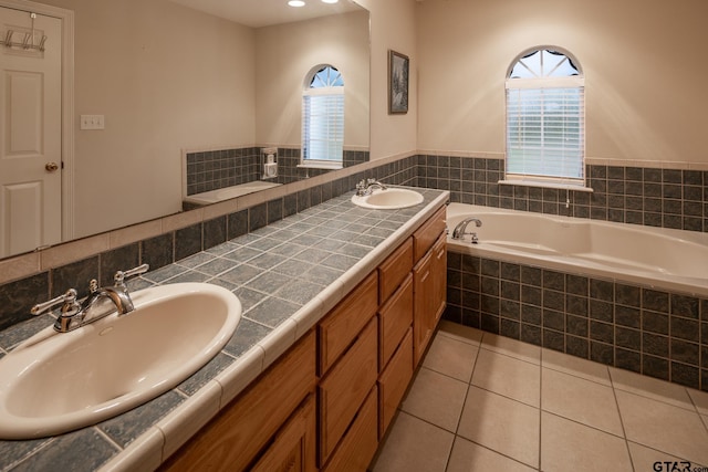 bathroom with vanity, tile patterned flooring, and tiled bath