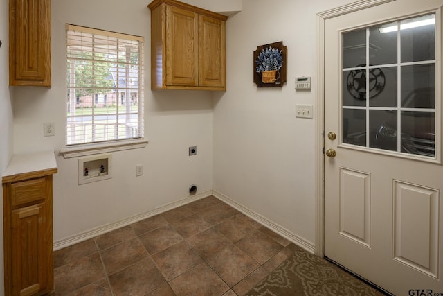 clothes washing area with electric dryer hookup, hookup for a washing machine, and cabinets