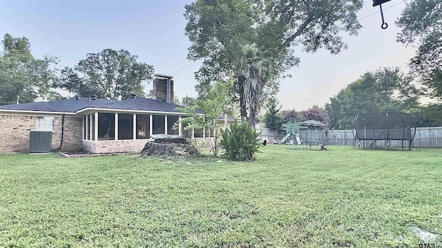 3004 Tower Dr, Tyler, TX 75701 - fenced backyard with a trampoline, a playground, and a sunroom