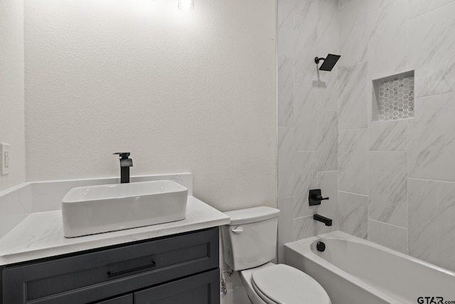 full bathroom featuring shower / bath combination, a textured wall, vanity, and toilet