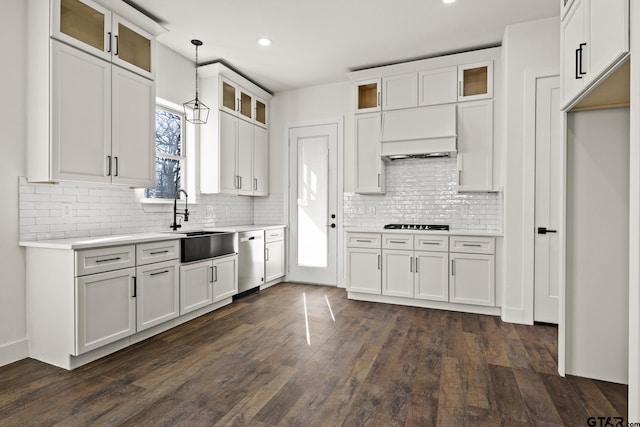 kitchen with white cabinets, dishwasher, dark wood-style floors, light countertops, and a sink