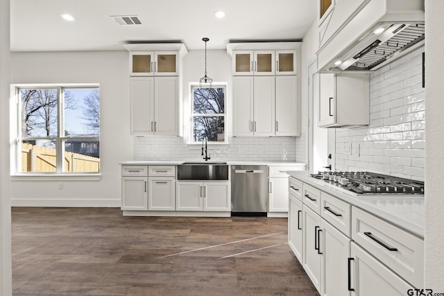 kitchen featuring visible vents, appliances with stainless steel finishes, custom exhaust hood, light countertops, and pendant lighting