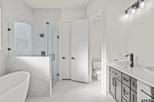 full bathroom featuring marble finish floor, a soaking tub, toilet, a sink, and a shower stall