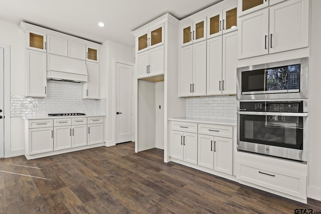 kitchen featuring stainless steel appliances, light countertops, white cabinets, and dark wood-type flooring