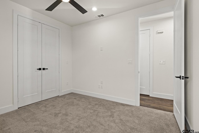 unfurnished bedroom featuring carpet floors, baseboards, visible vents, and ceiling fan