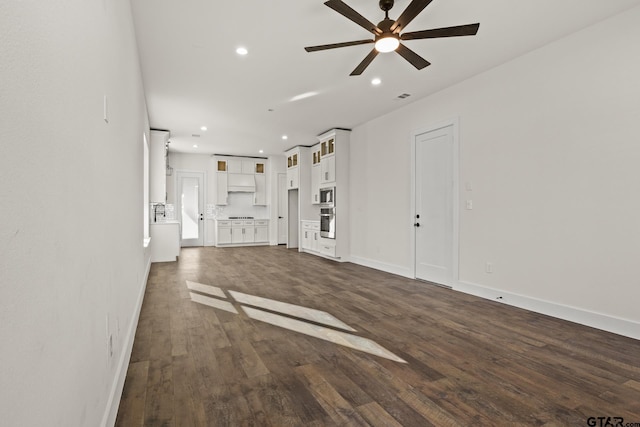 unfurnished living room with baseboards, dark wood-style flooring, and recessed lighting