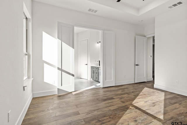 empty room with baseboards, wood finished floors, visible vents, and a ceiling fan