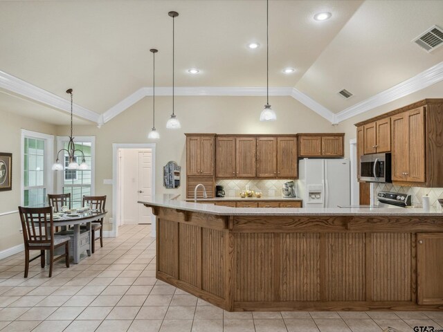 121 Rolling Rdg, Holly Lake Ranch, TX 75765 - kitchen featuring appliances with stainless steel finishes, brown cabinetry, decorative backsplash, light tile patterned floors, and crown molding