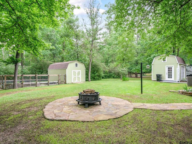 121 Rolling Rdg, Holly Lake Ranch, TX 75765 - view of yard with an outdoor fire pit, an outdoor structure, a storage unit, and a patio