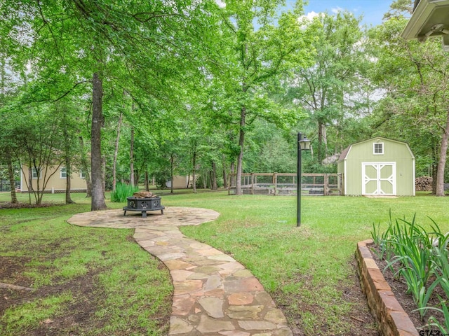 121 Rolling Rdg, Holly Lake Ranch, TX 75765 - view of yard featuring an outdoor fire pit, a storage unit, an outbuilding, and view of wooded area