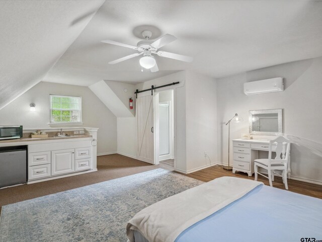 121 Rolling Rdg, Holly Lake Ranch, TX 75765 - bedroom featuring a wall mounted air conditioner, a barn door, a sink, lofted ceiling, and baseboards