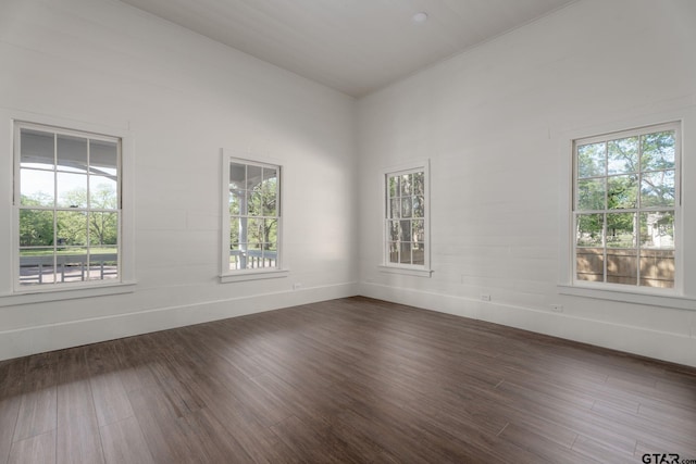 spare room with dark wood-style floors and baseboards