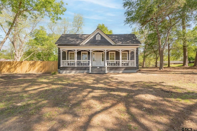 view of front of property with a porch and fence